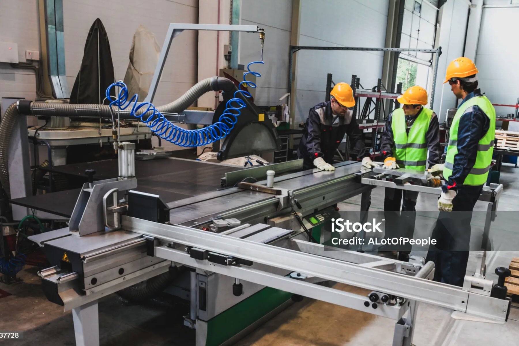 Dipendenti al lavoro in una piccola officina metalmeccanica con macchinari CNC