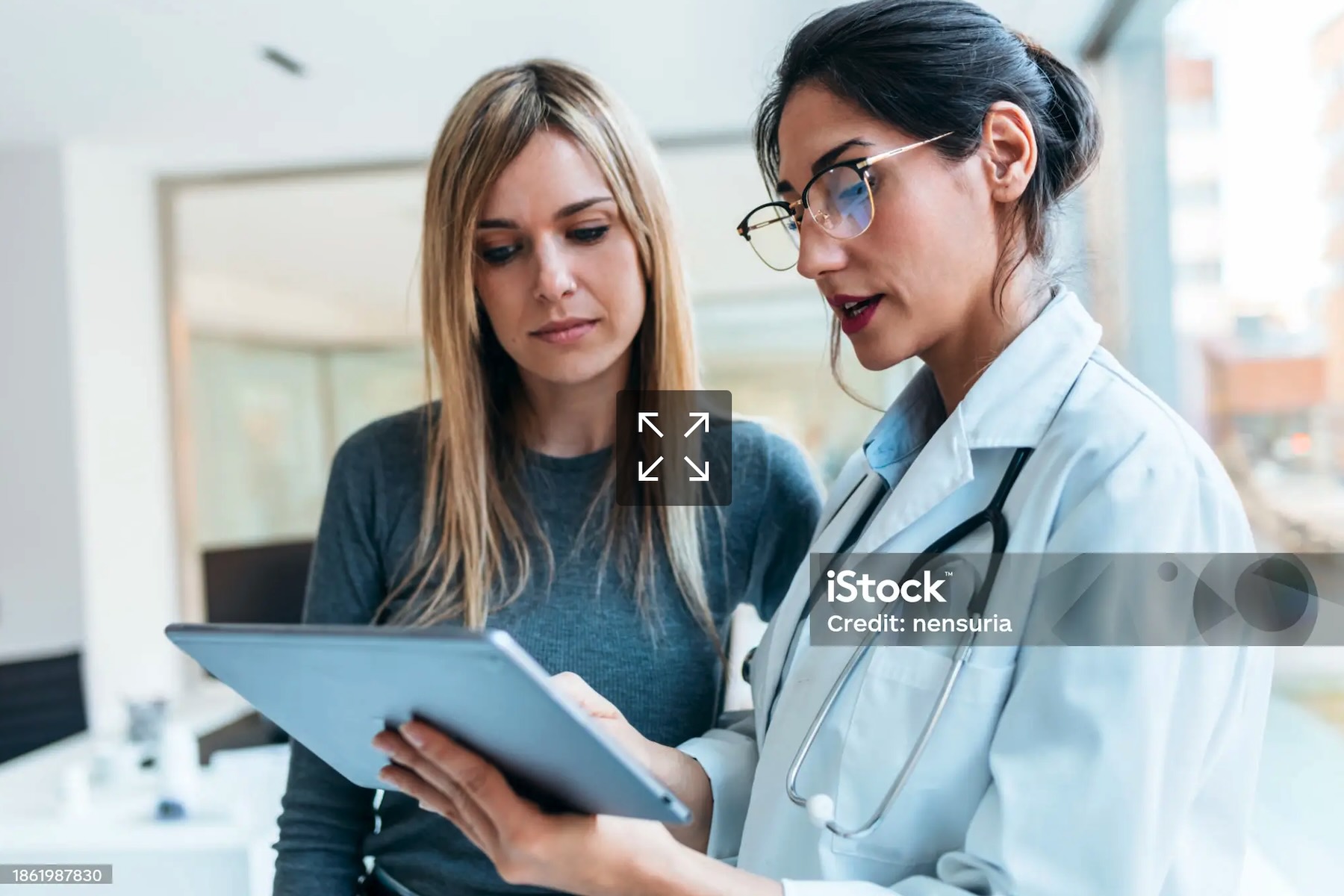 Medico illustra a una paziente informazioni sul trattamento durante una consulenza con tablet