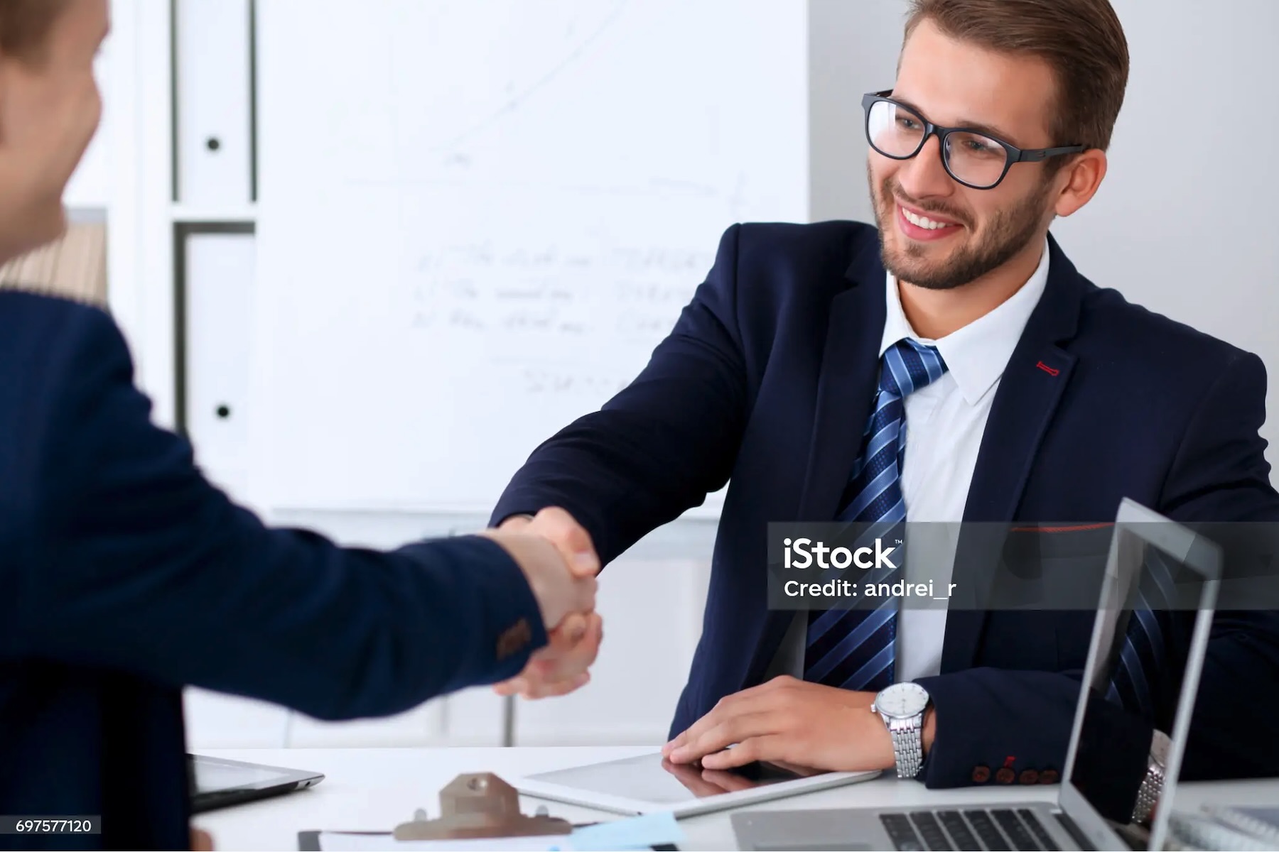 Cliente e consulente si stringono la mano durante una consulenza sul rinnovo della cessione del quinto, con documenti sulla scrivania